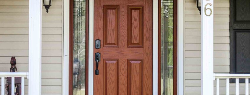 Front porch of a light tan color house showing a classy 3 panel Right-Hand Inswing Front Door with Sidelites decorative glasses. With two outdoor lamps to each side of the door. Lo's Contracting Entry Door Replacement Portland