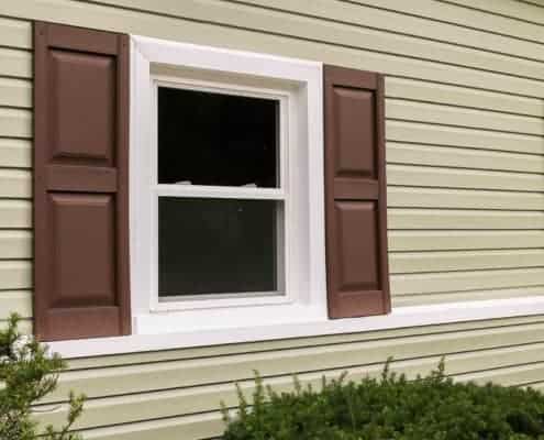 Double pane White trimm vinyl energy efficient window installed in a light olive color painted exterior walls of a house. Windows and doors installation, Windows and doors replacement, energy efficient windows and doors replacement, energy saving windows and doors installation