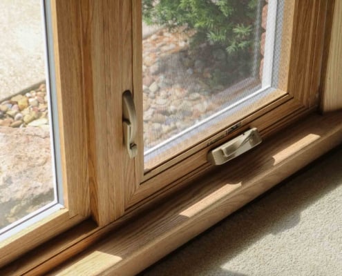 Oak color double pane modern custom windows with brass hardware installed to allow visibility to the outside landscape Sliding door installation, Patio door installation, Front door installation, windows and doors installation, energy efficient windows and doors replacement